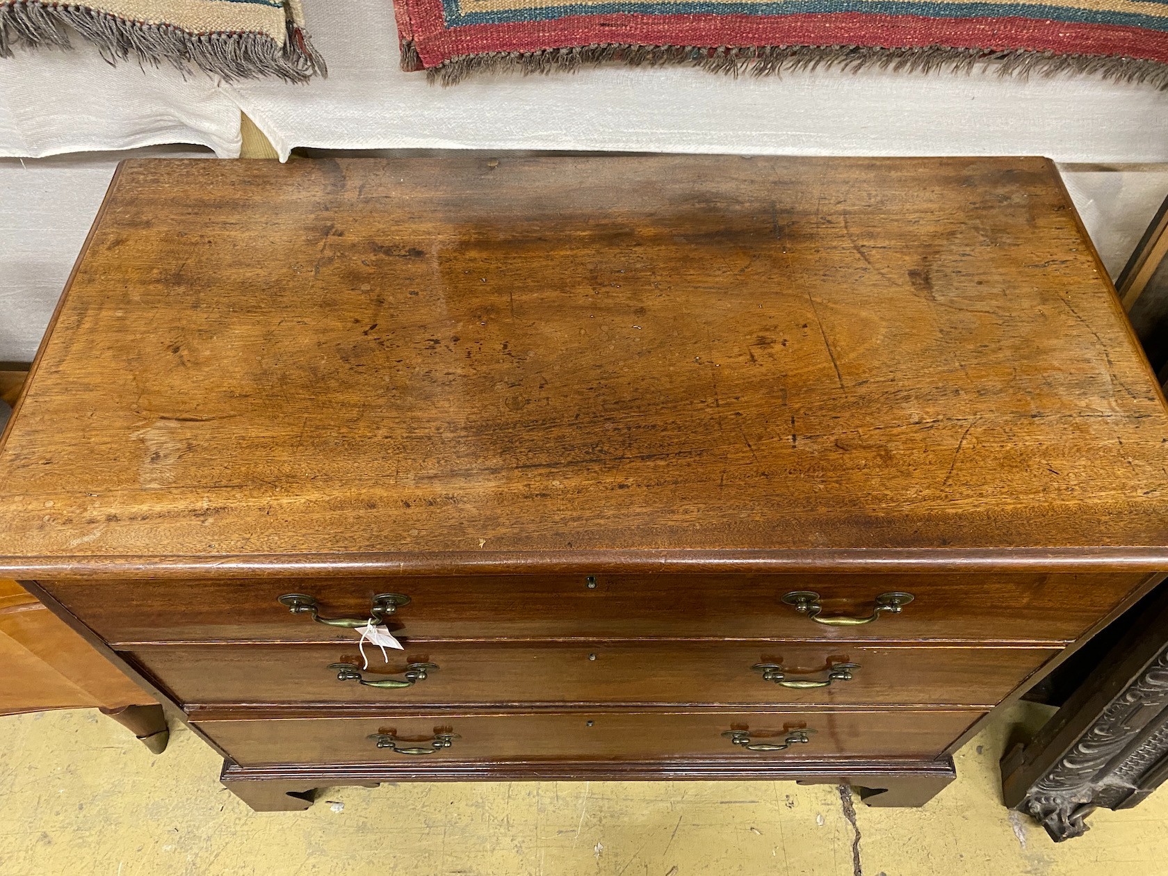 A George III mahogany chest of three long drawers, bracket supports, width 114cm, depth 55cm, height 91cm